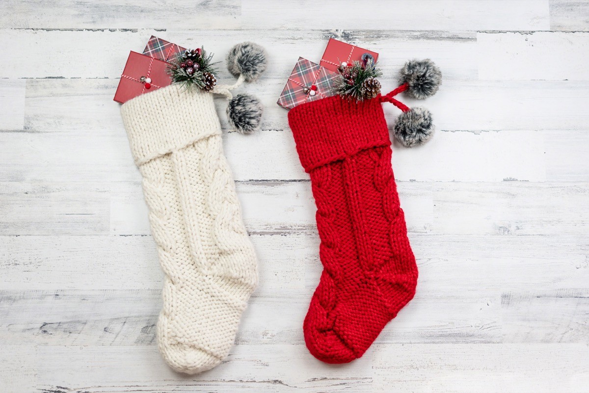 red and white cable knit christmas stockings on white background