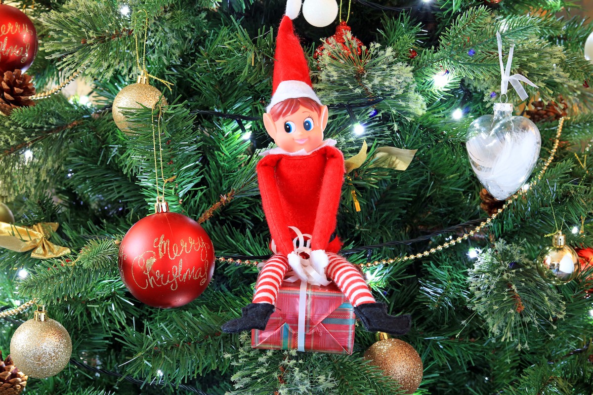 An elf ornament on a Christmas tree.