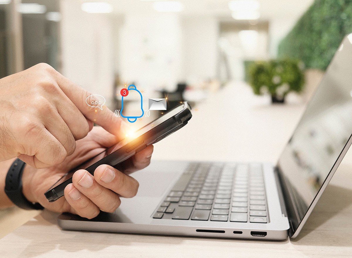 Man holding cell phone gets a popup alert