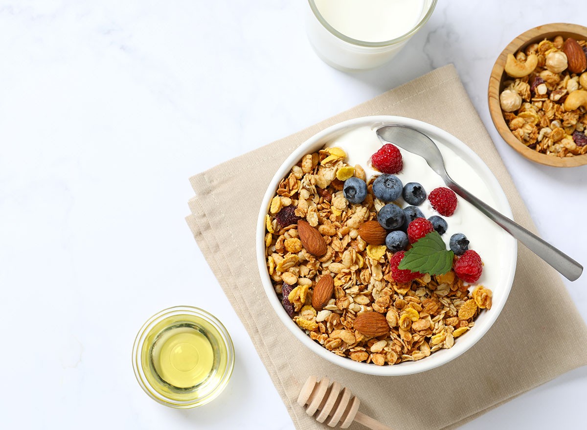 A bowl of granola with yogurt and berries on a table top