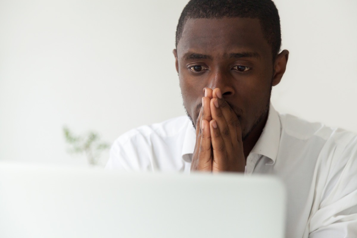 A man sitting at his computer feeling stressed and anxious