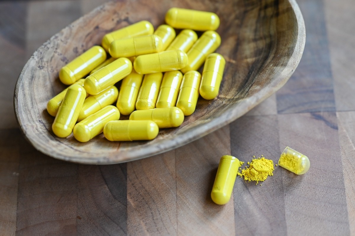 yellow Berberine supplements in a wooden bowl
