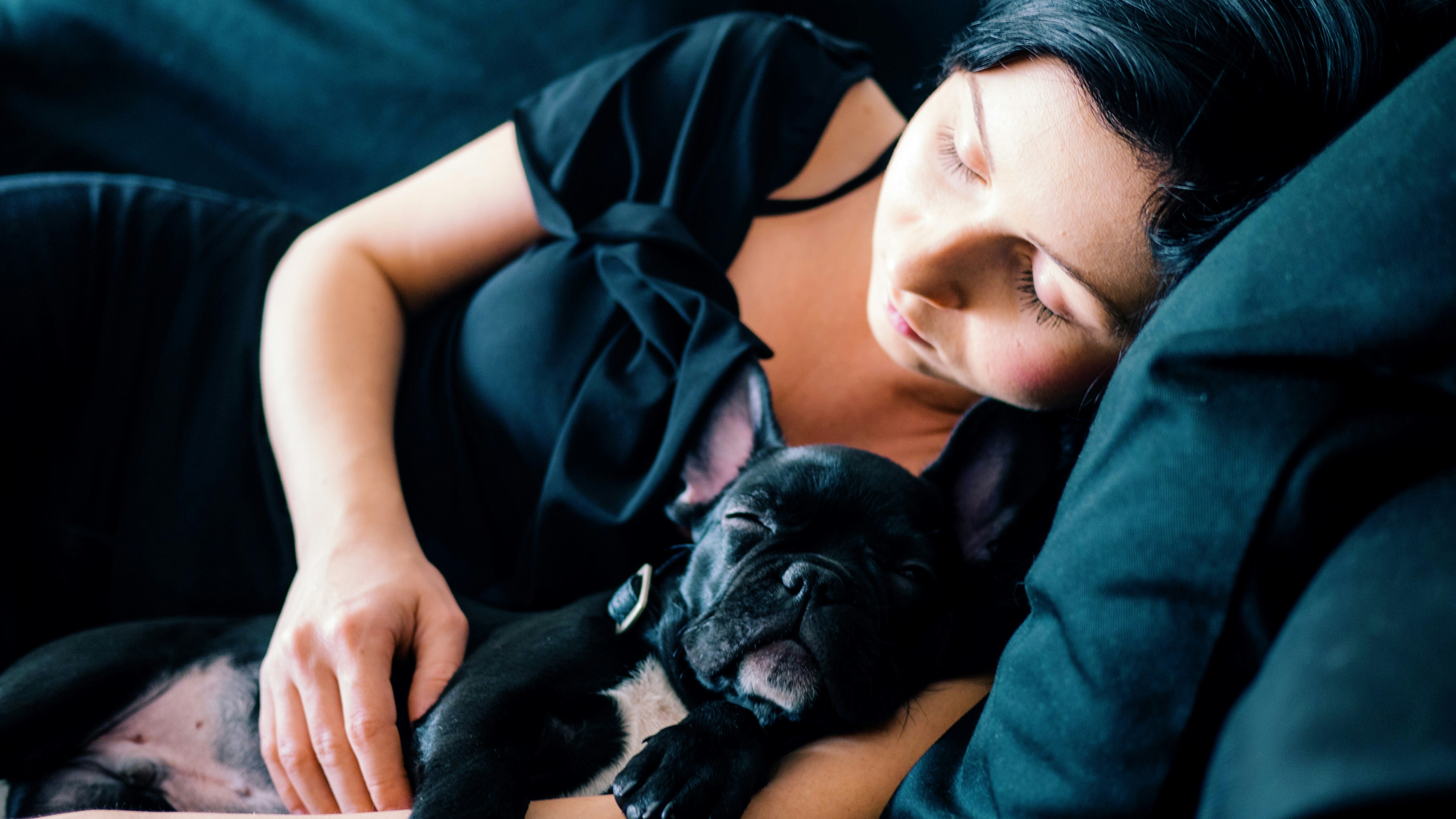 person sleeps with their dog