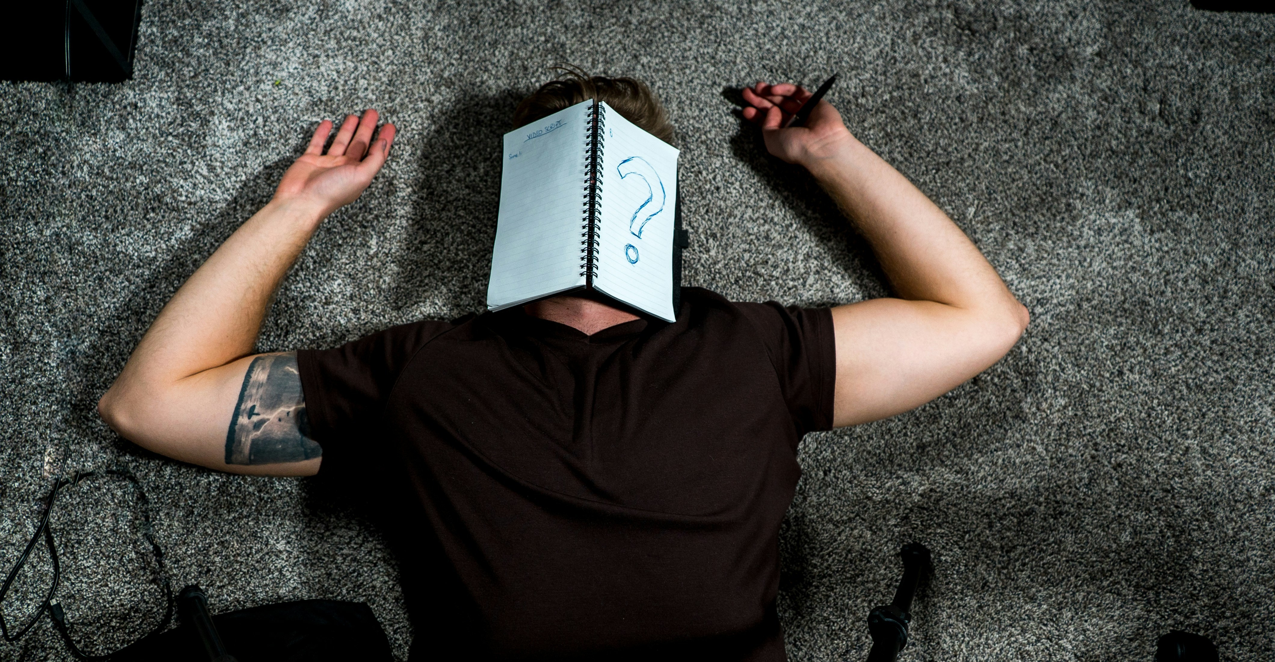 an exhausted person wears a notebook with a question mark