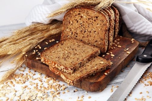 Whole grain rye bread with seeds on rustic background