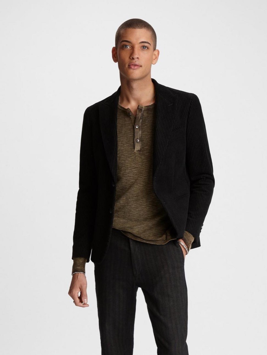 young man in brown shirt, black blazer, and black jeans