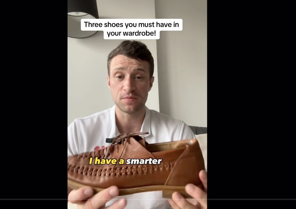 Paul the Podiatrist holding up tan leather boat shoes